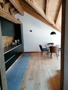 eine Küche und ein Esszimmer mit einem Tisch und Stühlen in der Unterkunft Chalet les Ecureuils Apartment Penthouse Suite in Crésuz