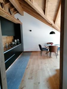 a kitchen and dining room with a table and chairs at Chalet les Ecureuils Apartment Penthouse Suite in Crésuz