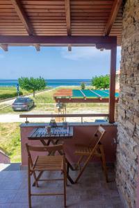 una mesa y sillas en un patio con vistas al océano en Seaview Maisonette, en Ierissos