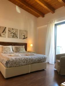 a bedroom with a bed and a large window at Residence i Fiori in Piantedo