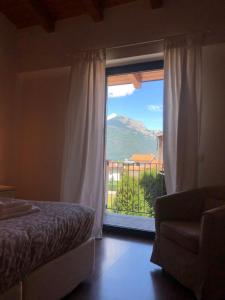 a bedroom with a bed and a window with a view at Residence i Fiori in Piantedo