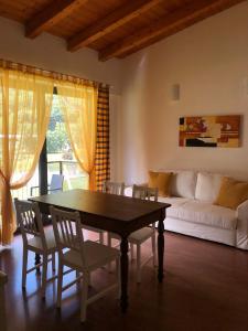 ein Wohnzimmer mit einem Tisch, Stühlen und einem Sofa in der Unterkunft Residence i Fiori in Piantedo
