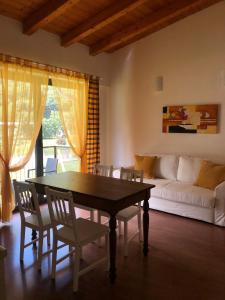 a living room with a table and chairs and a couch at Residence i Fiori in Piantedo +26 photos