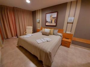 a bedroom with a large bed with two towels on it at HOTEL RURAL San Pedro in Frómista