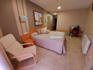 Cette chambre comprend un grand lit et une chaise. dans l'établissement HOTEL RURAL San Pedro, à Frómista