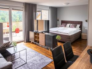 a bedroom with a bed and a living room at der Sonnberg - Alpinlodges in Zell am See