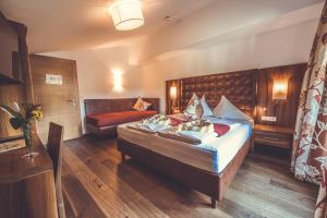 um quarto de hotel com uma cama e um sofá em Gasthof Skirast em Kirchberg in Tirol
