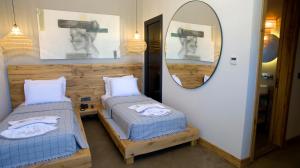 a room with two beds and a mirror at Dmira Alacati in Alaçatı