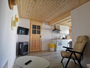 a living room with a table and a chair and a kitchen at Willa Bloom in Rewa