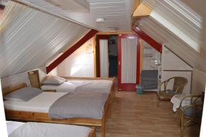 a bedroom with two beds and a chair in a room at Pension Neske in Beesel