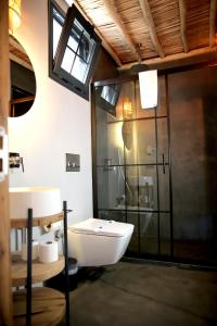 a bathroom with a toilet and a glass shower at Dmira Alacati in Alaçatı