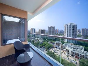 een kamer met een balkon met uitzicht op de stad bij Mangrove Tree Resort World Sanya Bay-Kapok in Sanya