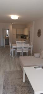 uma sala de estar com mesas brancas e cadeiras brancas em La Mer Residence em Golden Sands