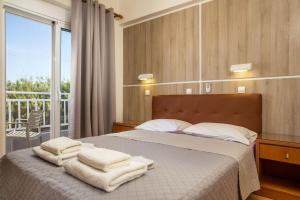a bedroom with a bed with towels on it at Rea Hotel in Faliraki