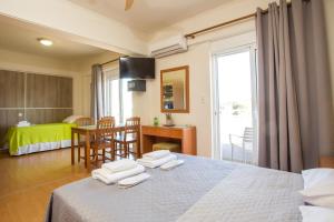 a hotel room with a bed and a table and chairs at Rea Hotel in Faliraki