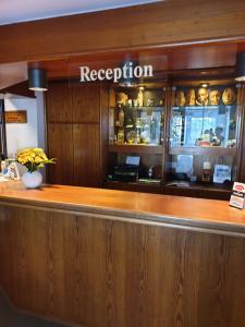 a bar in a restaurant with a sign that reads reception at Heidehotel Anna in Soltau