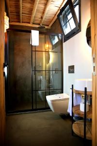 a bathroom with a glass shower and a sink at Dmira Alacati in Alaçatı