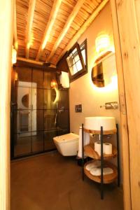 a bathroom with a shower and a toilet and a sink at Dmira Alacati in Alaçatı