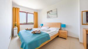 um quarto com uma cama com um cobertor azul em Apartamenty Sun & Snow Lido Sarbinowo em Sarbinowo