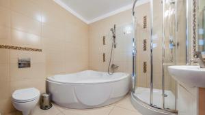 łazienka z wanną, toaletą i umywalką w obiekcie Apartamenty Sun & Snow Lido Sarbinowo w Sarbinowie