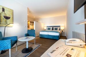 a hotel room with a bed and a table and chairs at Hotel Historischer Krug in Oeversee