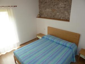 a bedroom with a bed with a blue blanket on it at Maso Gaitem in Drena