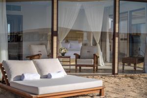 a living room with a couch and a bedroom at Regency Sealine Camp in Mesaieed