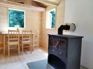 a wood stove in a room with a table at Celoroční GLAMPING v pohodlném domečku in Výprachtice