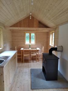 a kitchen and dining room of a log cabin with a stove at Celoroční GLAMPING v pohodlném domečku in Výprachtice
