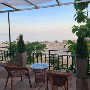 eine Terrasse mit Stühlen und Tischen und Blick auf den Strand in der Unterkunft Maria Tereza Bungalows in Baltschik + 9 Fotos