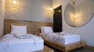 a bedroom with two twin beds and a mirror at Dmira Alacati in Alaçatı