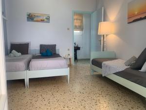 Zimmer mit 2 Betten und einem Tisch mit einer Lampe in der Unterkunft Villa Loula Apartment II in Poros