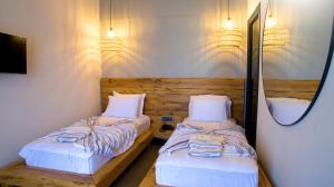 a bedroom with two beds and a mirror and lights at Dmira Alacati in Alaçatı