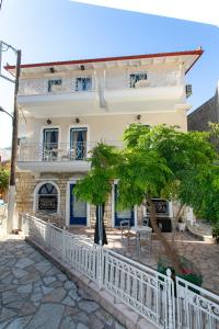 a white fence in front of a house at The Old Town hall in Parga