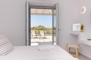 Кровать или кровати в номере Isalos Villas Naxos