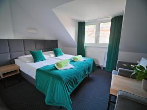 a hotel room with a large bed with green curtains at Kompleks Zagroń Istebna in Istebna