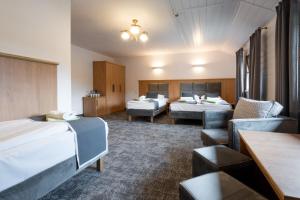 a hotel room with two beds and a couch at Kompleks Zagroń Istebna in Istebna +28 photos