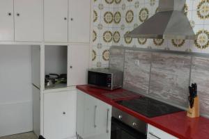 a kitchen with a microwave and a red counter top at Apartamentos Campomanes 2 in Campomanes