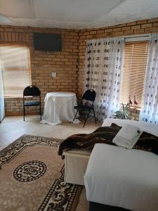 una camera con due letti e un tavolo in una stanza di Turning Point B&B a Città del Capo