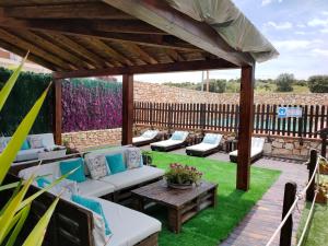 a patio with couches and a wooden pergola at El Mirador De Ruidera in Ruidera