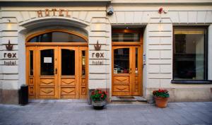 a building with two wooden doors and two potted plants at Rex Petit in Stockholm