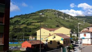 a green hill with a house and a mountain at Apartamentos Campomanes 2 in Campomanes +7 photos