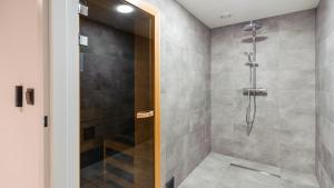 a shower with a glass door in a bathroom at Apartamenty Sun & Snow Mielno Olimpijska z sauną in Mielno