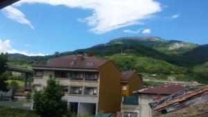 a view of a building with mountains in the background at Apartamentos Campomanes 2 in Campomanes