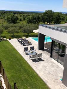 a group of chairs sitting next to a swimming pool at Villa Boiky - private pool and amazing sea view, Istria in Materada