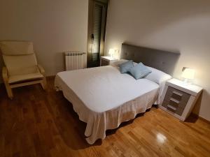 1 dormitorio con 1 cama blanca grande y 1 silla en APARTAMENTOS VIVE en Viveiro