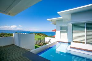 a villa with a swimming pool in front of a house at One Hagdan Villas in Boracay