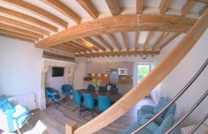 a living room with a wooden ceiling and blue chairs at Au pré des acajous in Pertheville-Ners