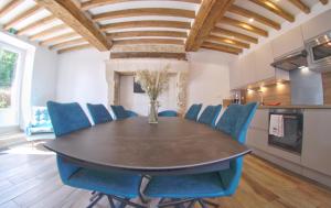 Pertheville-Ners的住宿－Au pré des acajous，一间带桌子和蓝色椅子的用餐室