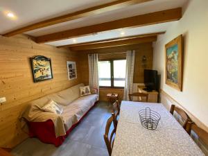 a living room with a couch and a table at L ALPIN bel appartement avec terrasse dans vieille ferme de montagne rénovée in Les Orres